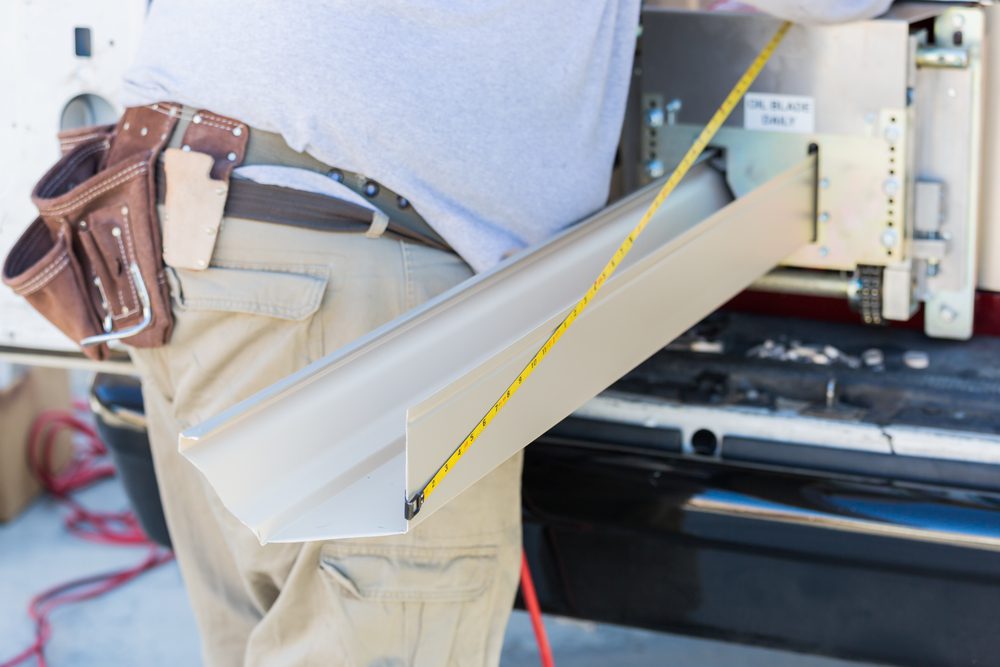 Worker,Measuring,An,Aluminum,Rain,Gutter,Feeding,Through,Seamless,Shaping
